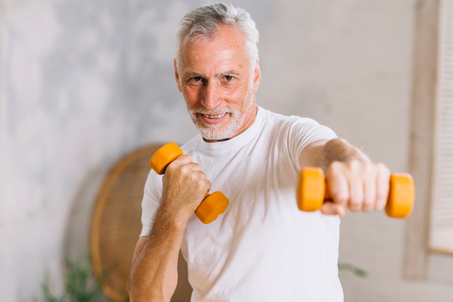 healthy smiling senior man working out with dumbbells